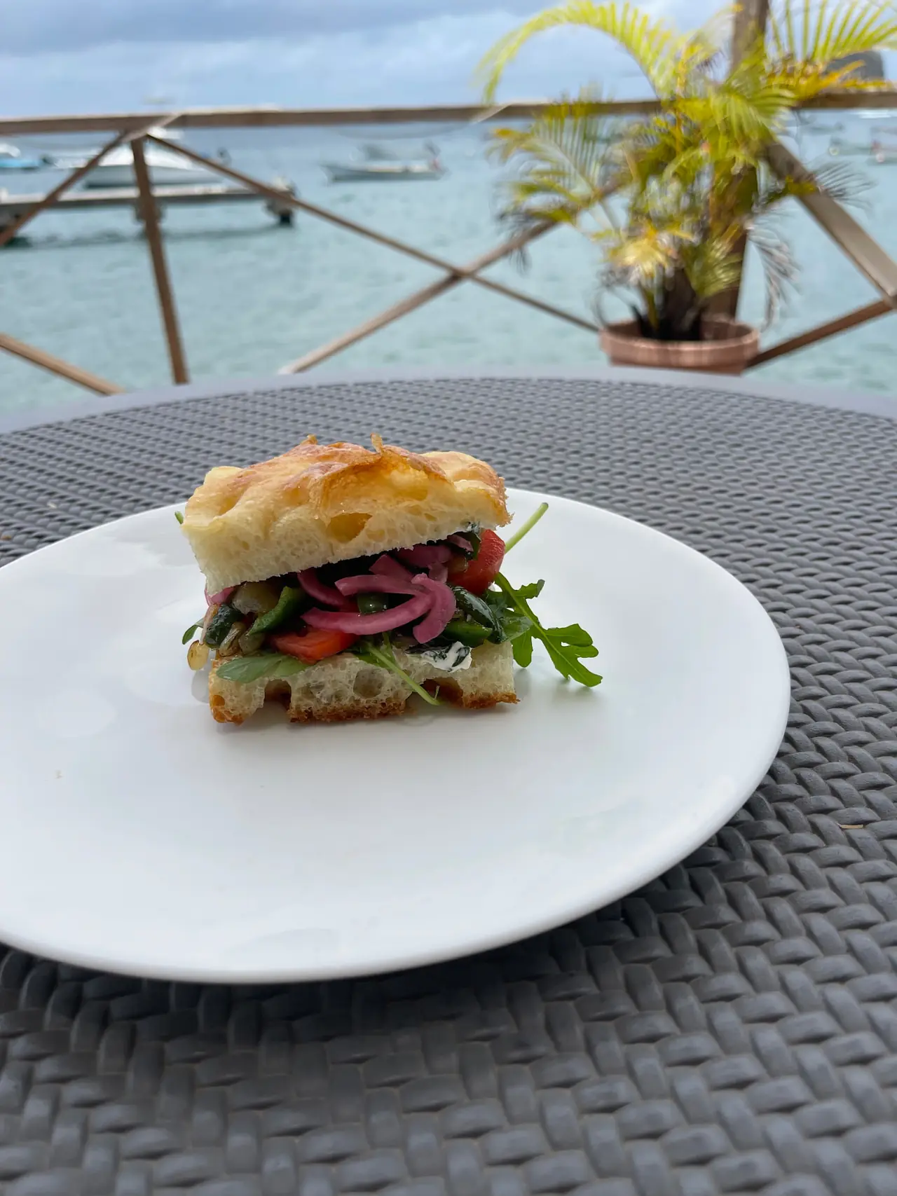 The Veggie focaccia with rocket, roasted peppers and pickled red onion, plated by the harbour